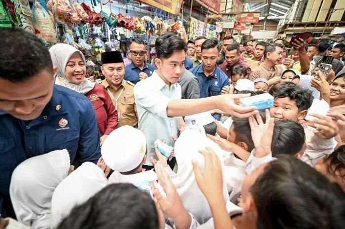 Potret Wakil Presiden RI, Gibran Rakabuming Raka yang tengah memberikan sekotak susu kepada anak-anak sekolah.