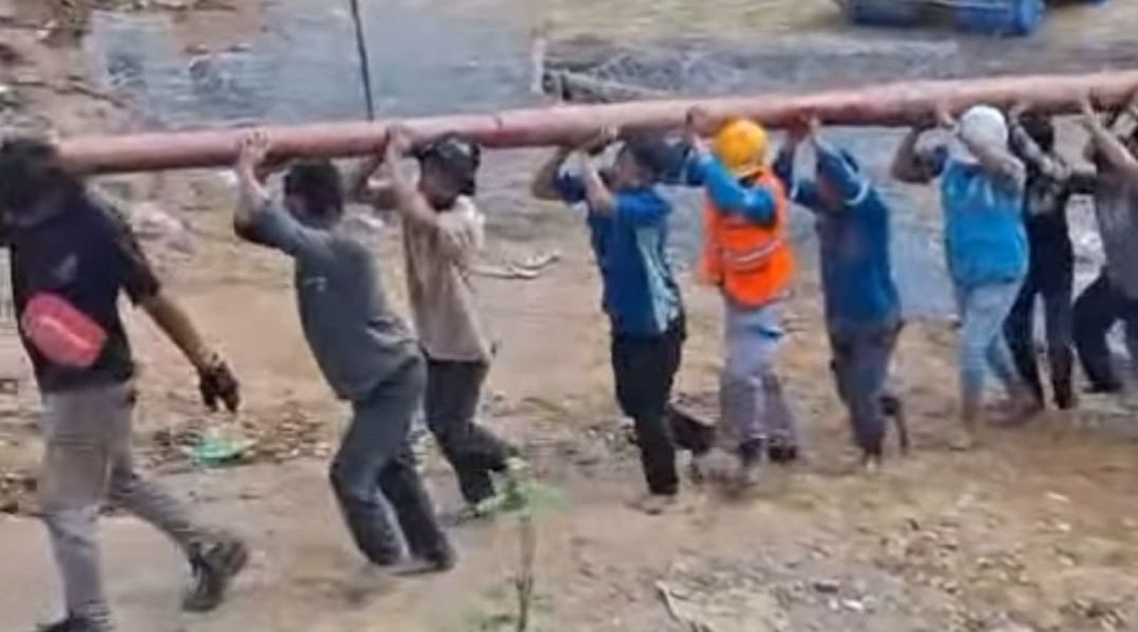 Warga dan Petugas PLN gotong royong menyeberangi sungai sambil membawa tiang listrik untuk desa terisolir di Aceh Tengah.