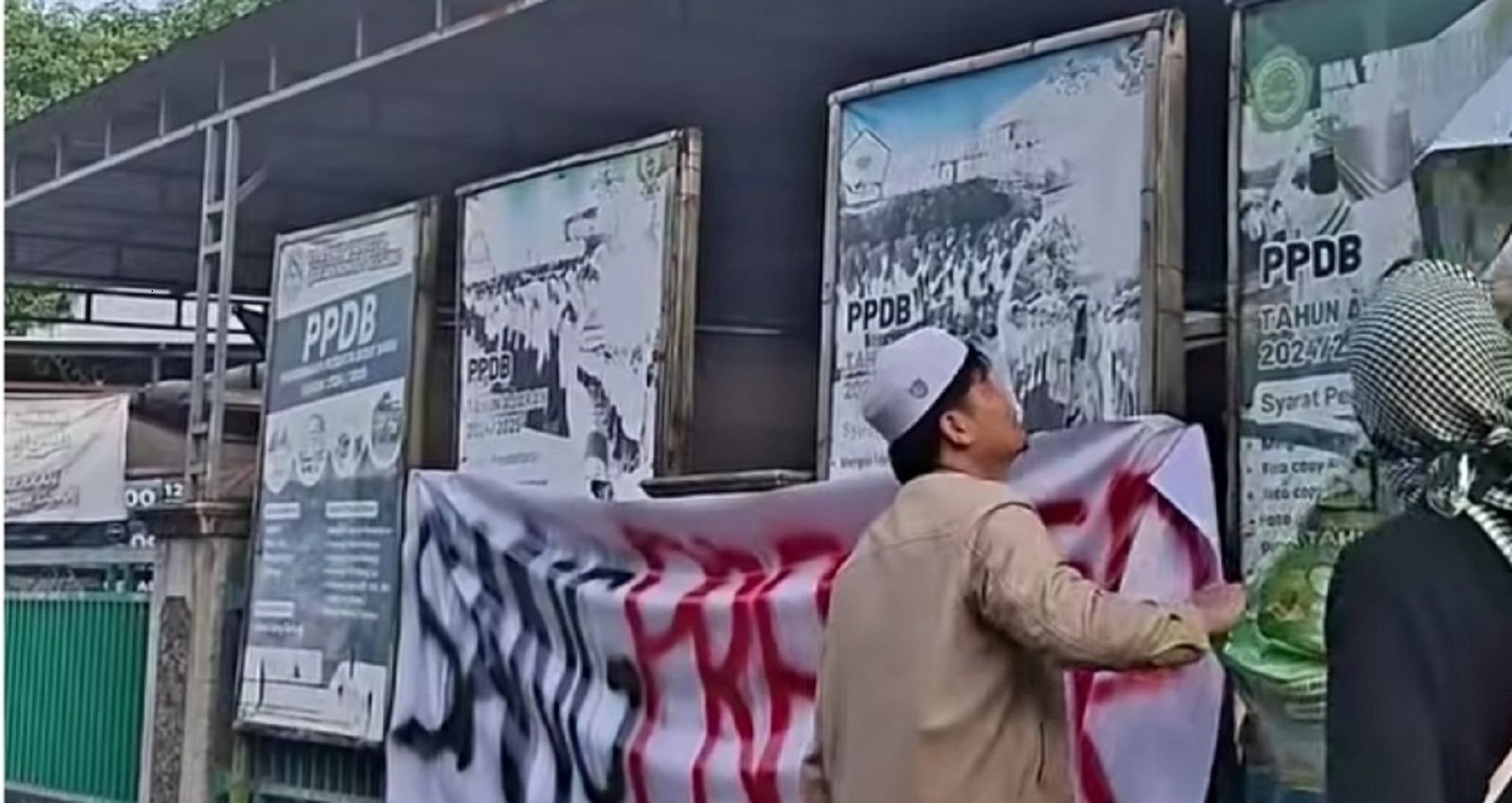 Massa saat melepas banner pengumuman di Ponpes Ndholo Kusumo dan memasang spanduk ‘Sang Predator’ di pagar pondok.