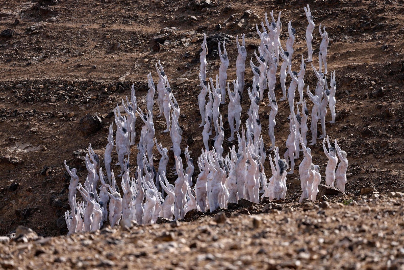 Ratusan laki-laki dan perempuan di Gurun pasir, Laut Merah, Israel telanjang dan tubuhnya di cat putih untuk proyek fotografi. (Foto: Dok Net/ Istimewa).
